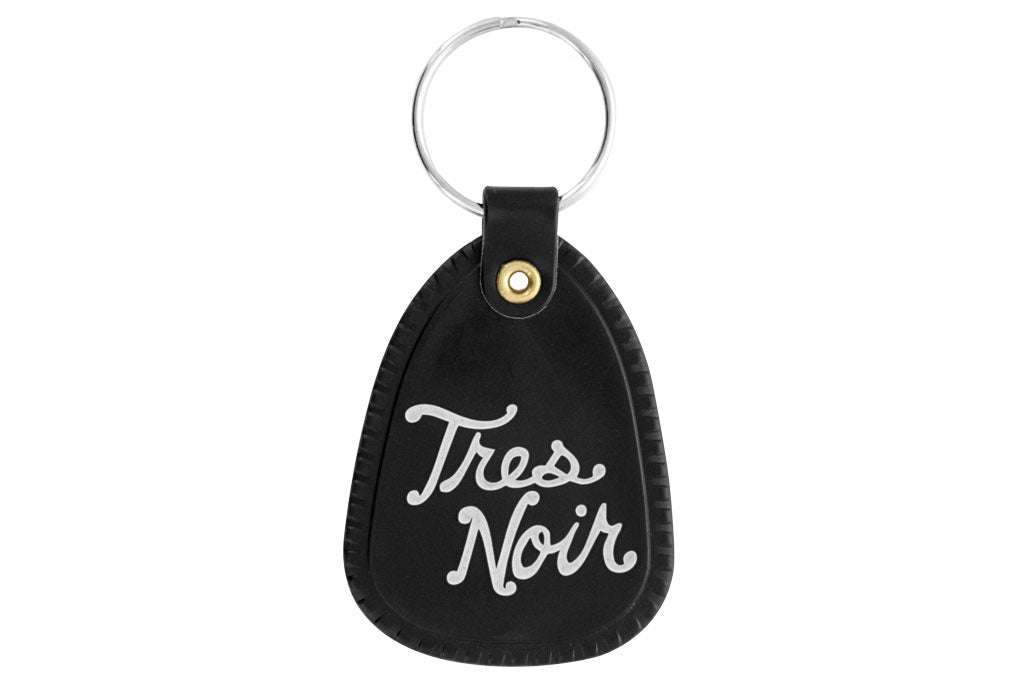 Black saddle key chain with Tres Noir script logo on back